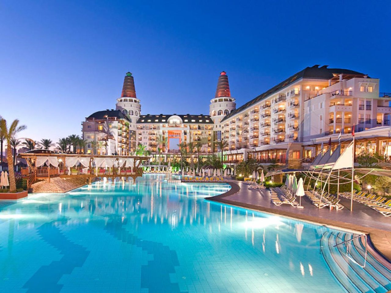 Delphin Diva Hotel Lara beleuchtetes Gebäude mit Pool bei Abenddämmerung