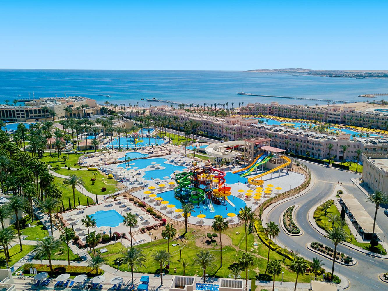 Beach Albatros Resort in Hurghada aus der Luft, Poollandschaft mit Aquapark und Rutschen, dahinter die Hotelgebäude und das Rote Meer