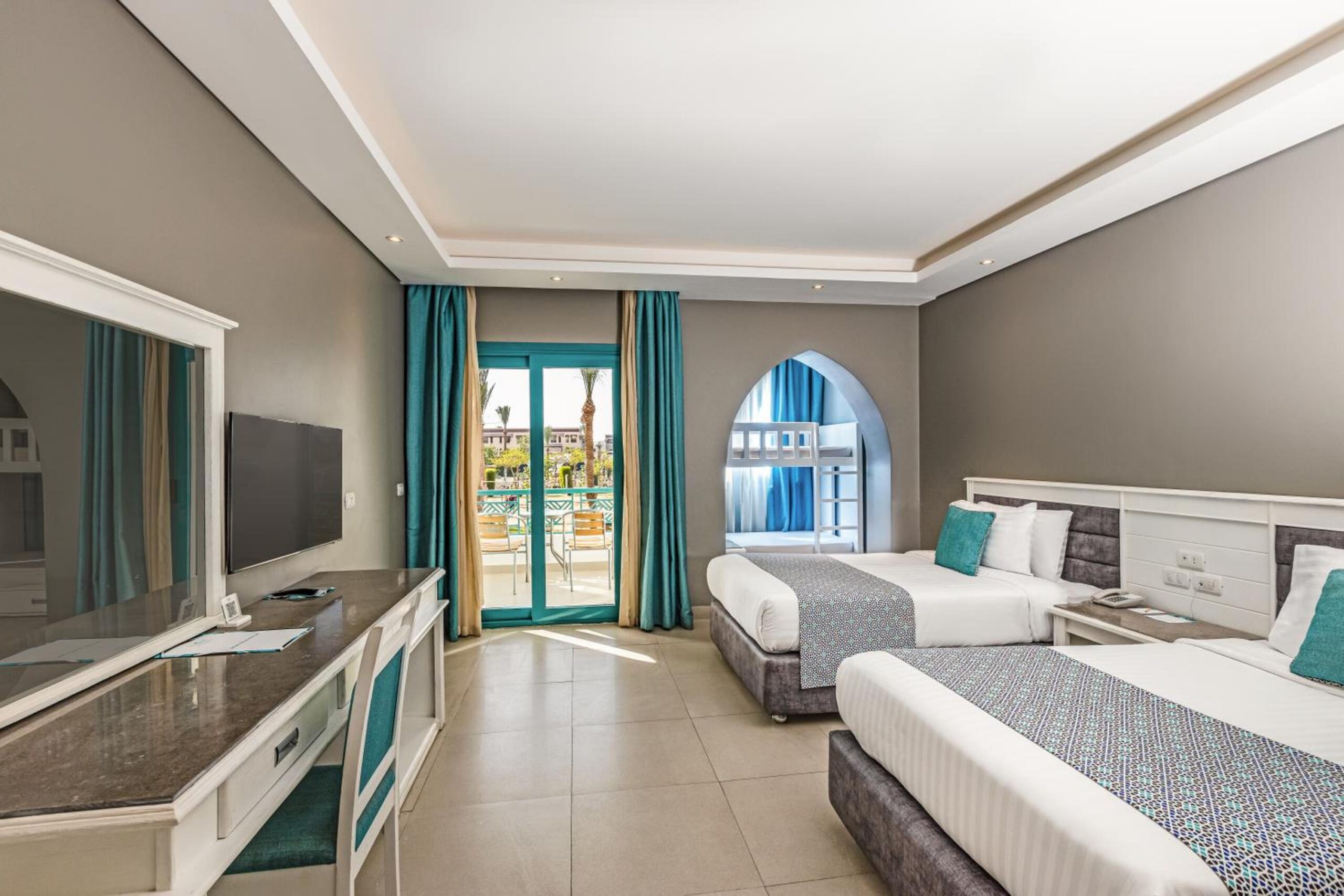 Familienzimmer im SUNRISE Garden Beach Resort in Hurghada mit zwei Betten, Etagenbett in einer Nische und Balkon zum Garten